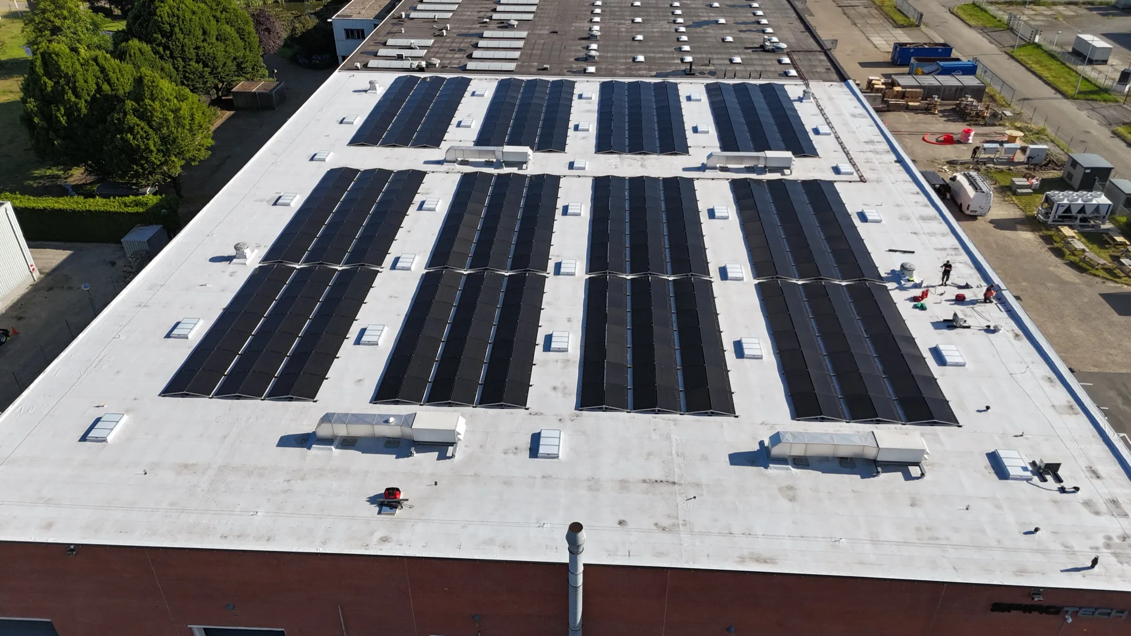 Bedrijfsdak met rijen zonnepanelen van bovenaf